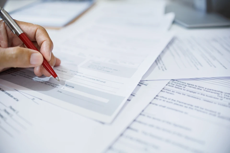 gros plan, main d'homme d'affaires examinant le document sur le bureau avant de signer un document important pour compl&eacute;ter le contrat d'affaires