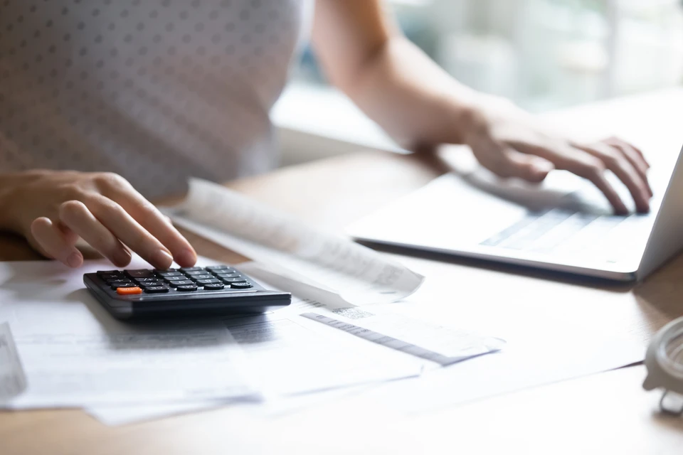 Scène de conseil financier en intérieur avec trois professionnels analysant des données d'assurance-vie sur tablette tactile